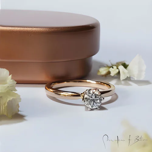 Anillo de compromiso en oro amarillo con piedra redonda brillante en engaste elevado