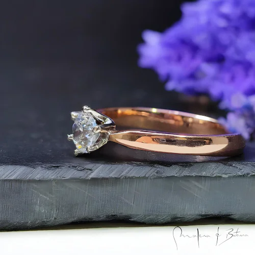 Un anillo de plata esterlina que presenta una piedra preciosa de amatista violeta de corte redondo vibrante como pieza central