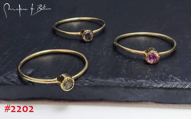 Tres anillos de oro con pequeñas piedras de colores (gris, rosa y morado). Número de artículo: #2202.