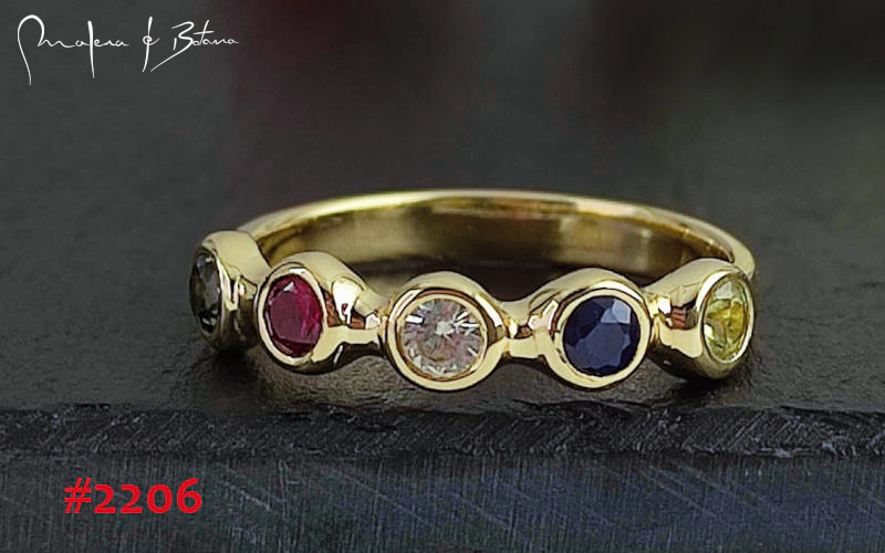 Anillo de oro con cinco piedras preciosas de colores (rubí, zafiro, diamante, topacio y otra piedra oscura). Número de artículo: #2206.