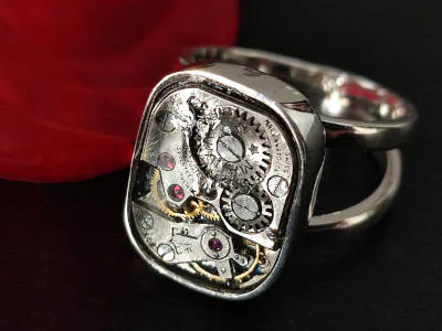 Primer plano de un anillo de plata con un mecanismo de reloj suizo vintage visible, modelo #2016 de Malena de Botana.