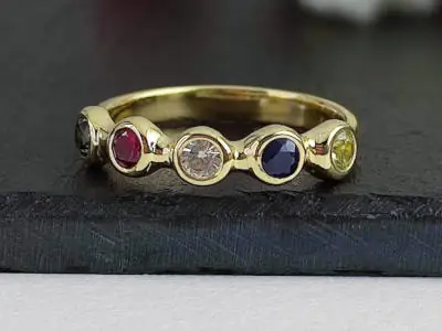 Anillo de oro con cinco piedras preciosas de colores (rubí, zafiro, diamante, topacio y otra piedra oscura). Número de artículo: #2206.