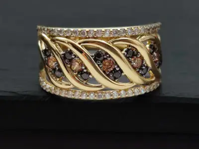 Anillo de oro con diseño entrelazado, decorado con diamantes y piedras marrones. Número de artículo: #2208.