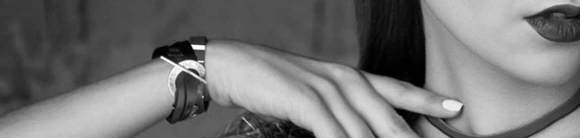 Composición que muestra dos pulseras: una de cuero marrón con un diseño circular y otra de metal, luciendo en la muñeca de una modelo, destacando su estilo moderno y artístico.

