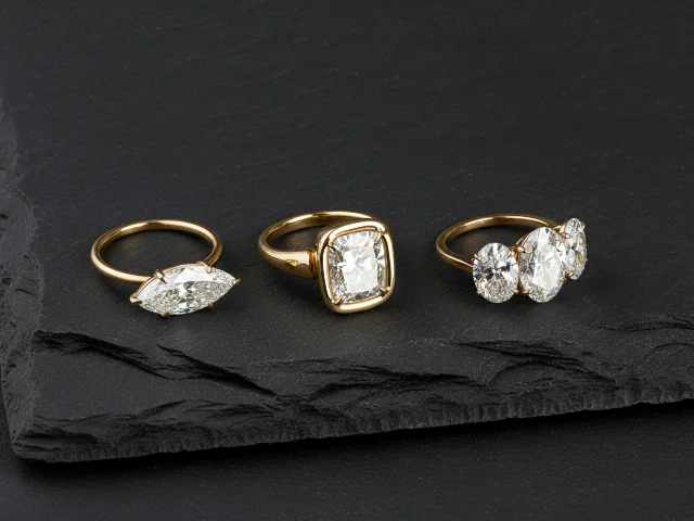 se muetra un anillo de compromiso con diferentes colores y un rubi con corte esmeralda