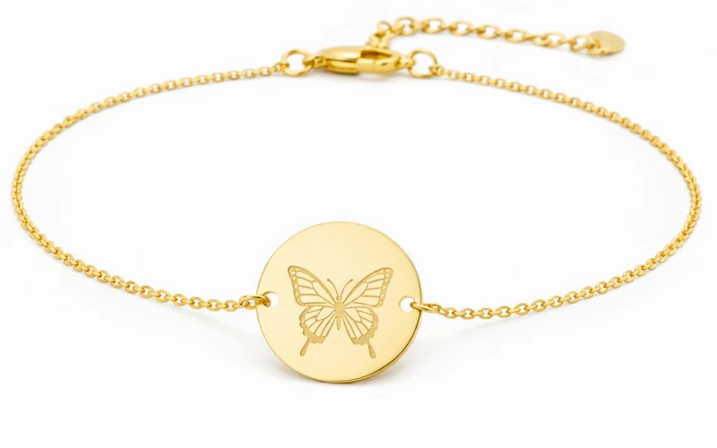 Pulsera de oro con medalla de mariposa grabada, diseño elegante y minimalista